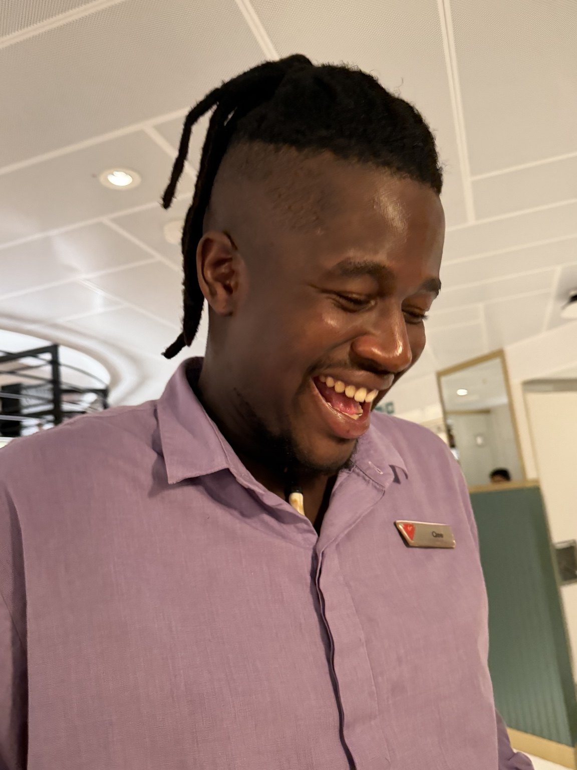 A smiling crew member wearing a name tag