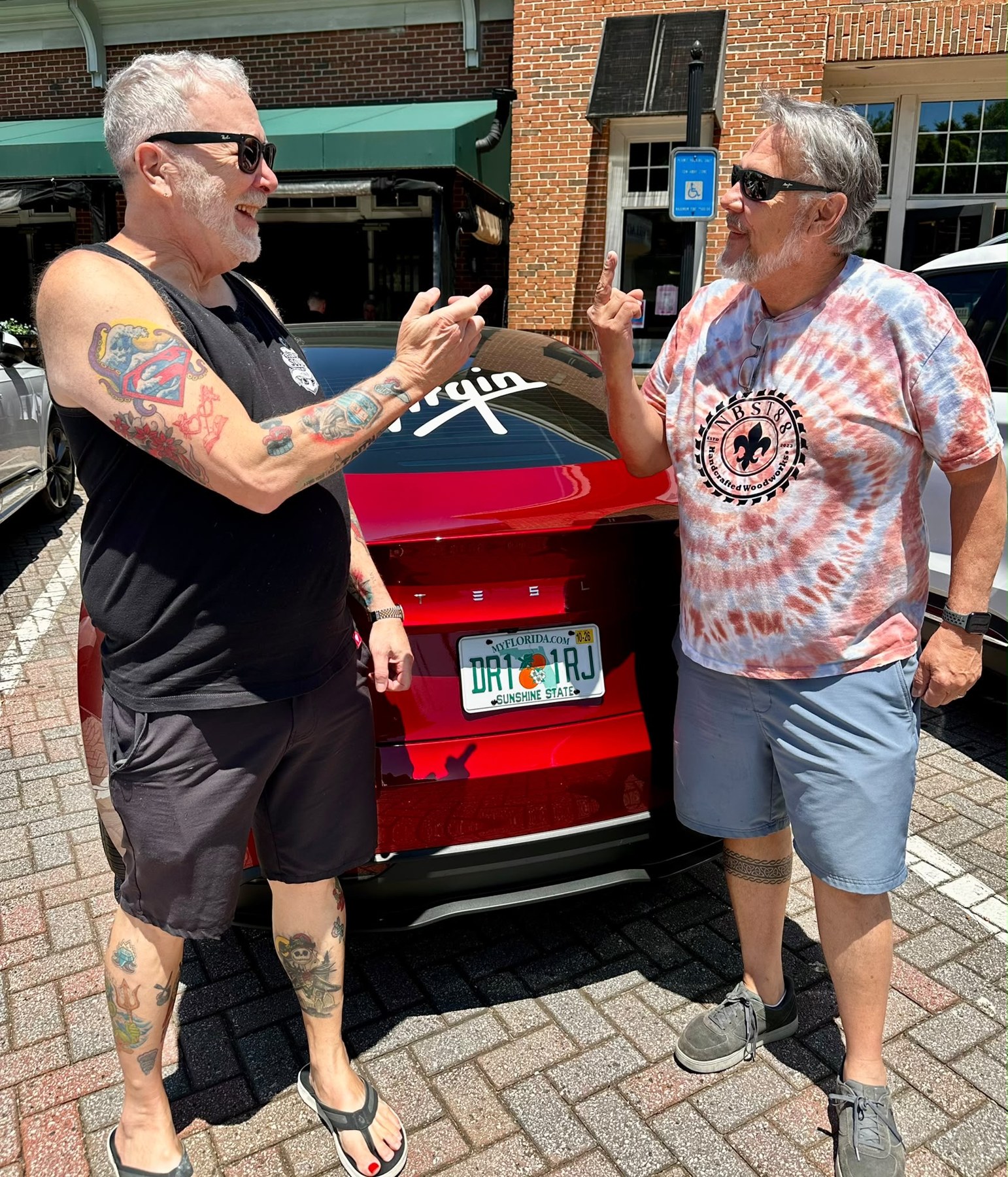 Mark and Steven beside Mark’s red Virgin-branded Tesla